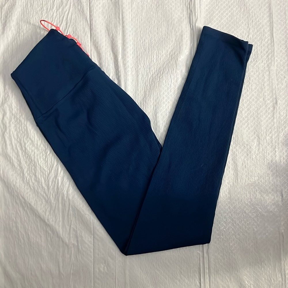 Blue ribbed leggings with a touch or pink on the back of the pant